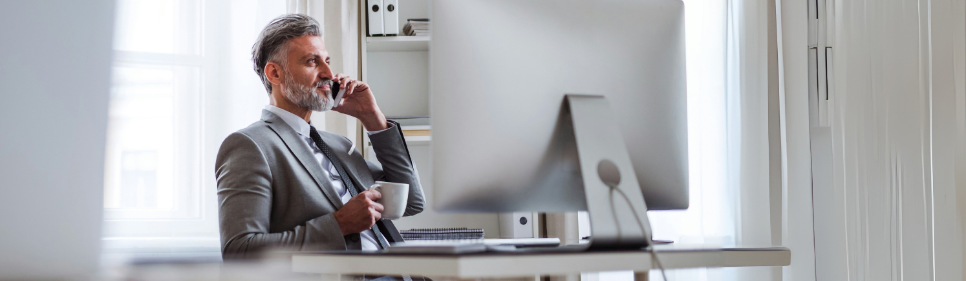 Guy on phone using computer