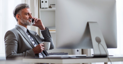 Guy on phone using computer